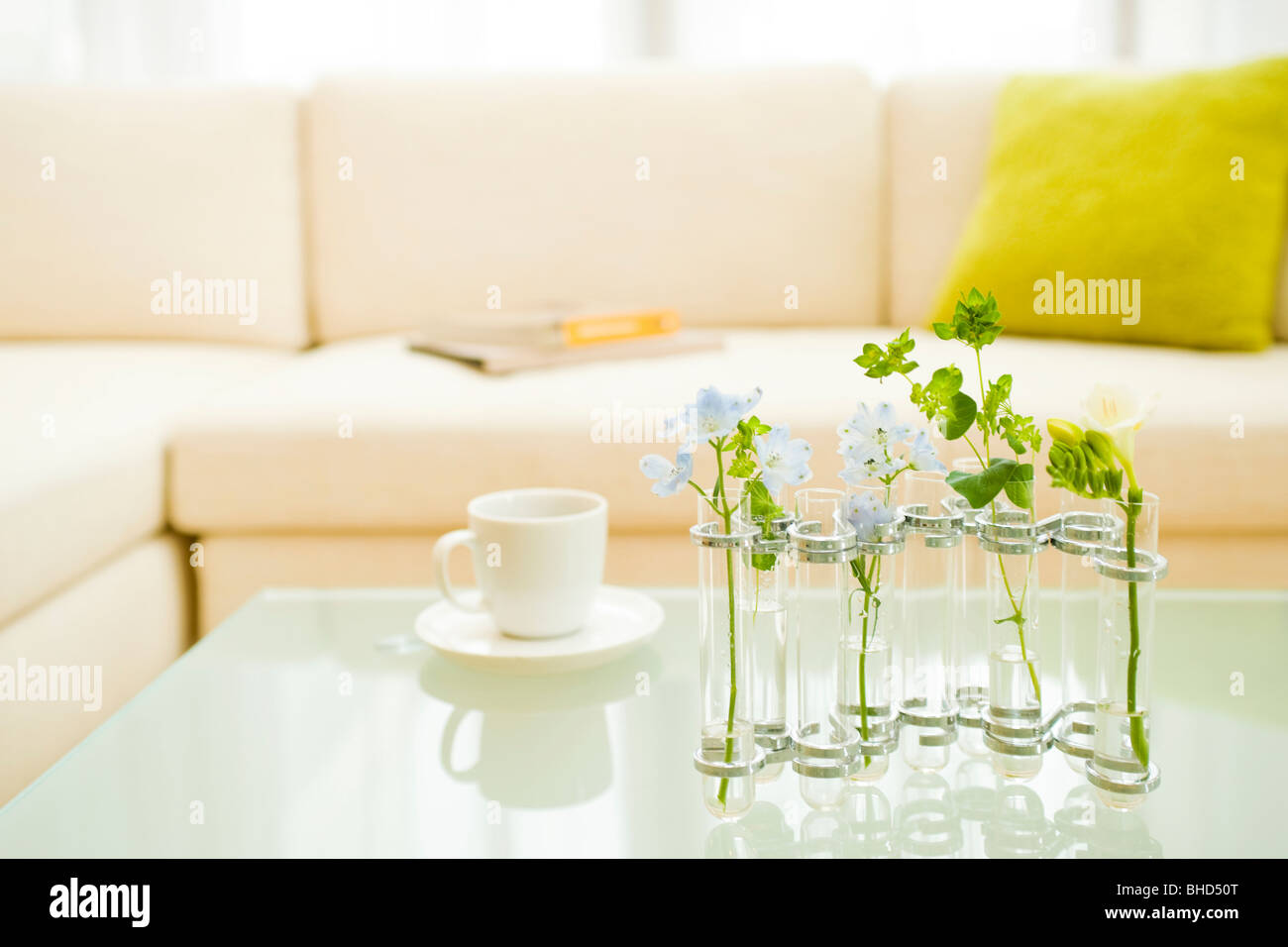 Mesa de café con flores en un jarrón y taza de café Foto de stock