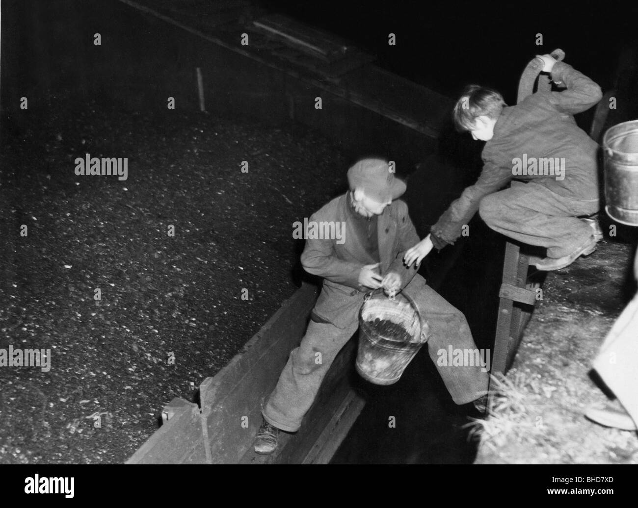 período de posguerra, penurias, miseria y hambre, dos hombres jóvenes robando carbón, 1940, Foto de stock