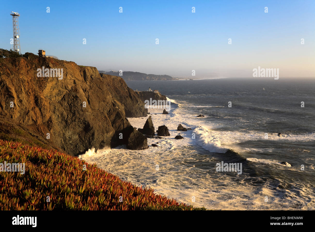 Las olas rompen en los acantilados a la Golden Gate National Recreation Area. Punta Bonita y es faro en la distancia. Foto de stock