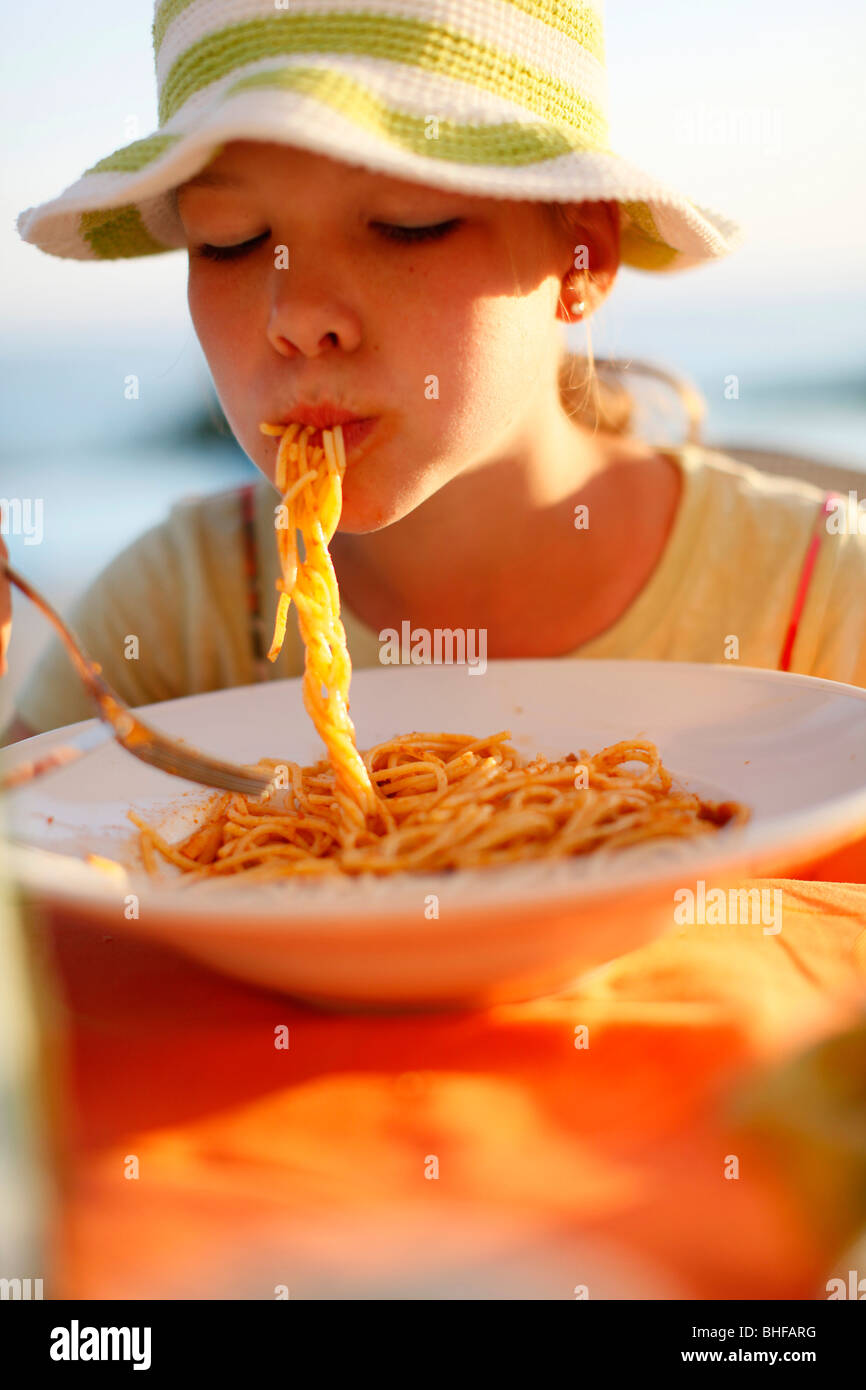 Muchacha comiendo espaguetis, Formentera, Islas Baleares, España Foto de stock