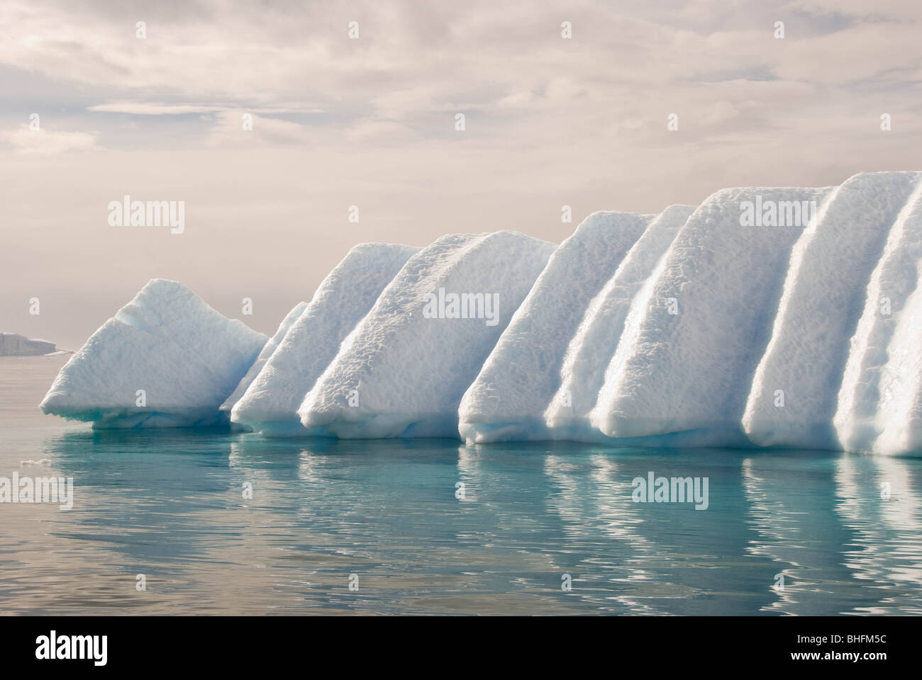 El derretimiento de un iceberg aprovechando las debilidades debido a las capas de nieve original crea una forma inusual. Foto de stock