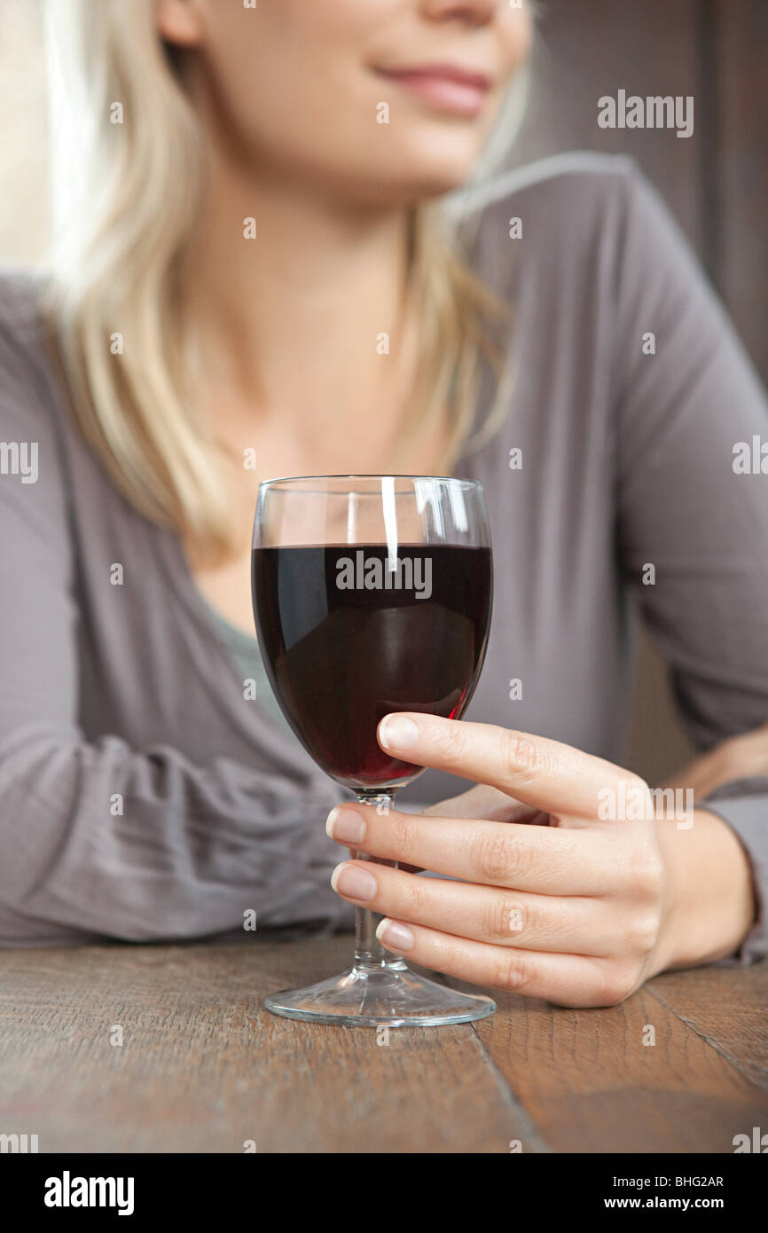 Mujer joven con vino tinto en bar Foto de stock