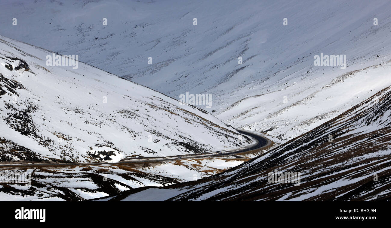 Vista de la A93 antiguos militares carretera que atraviesa las montañas cubiertas de nieve Glenshee, aberdeenshire, Escocia, Reino Unido. Foto de stock