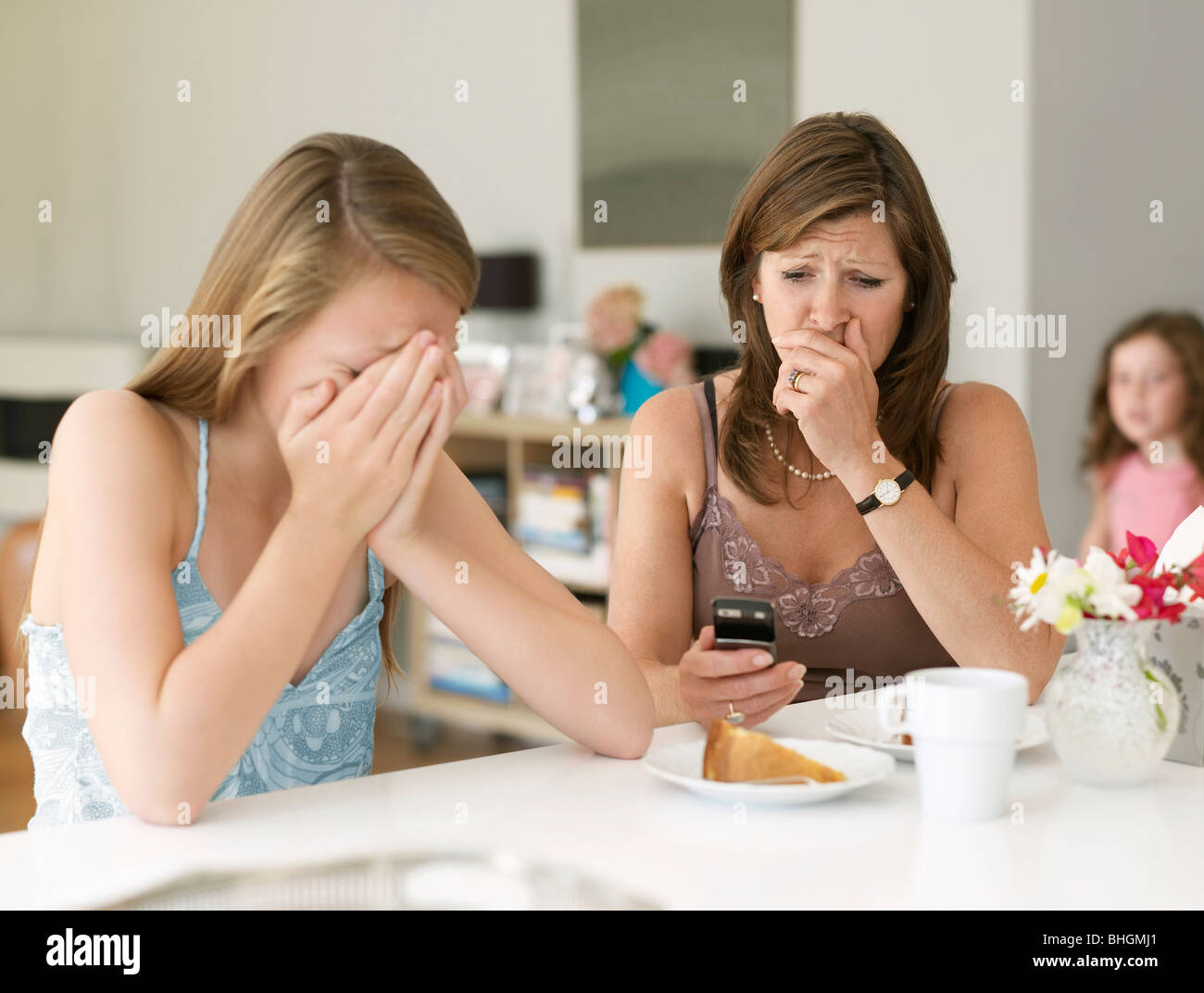 Madre ve cyber bullying en teléfono móvil Foto de stock