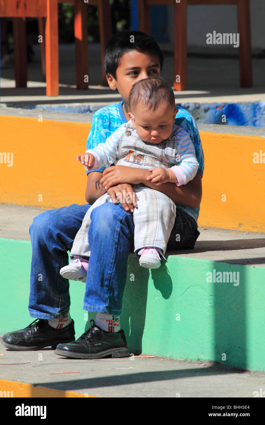 Niño sosteniendo a su hermano bebé. Caldas, Boyacá, Colombia, Sur America Foto de stock