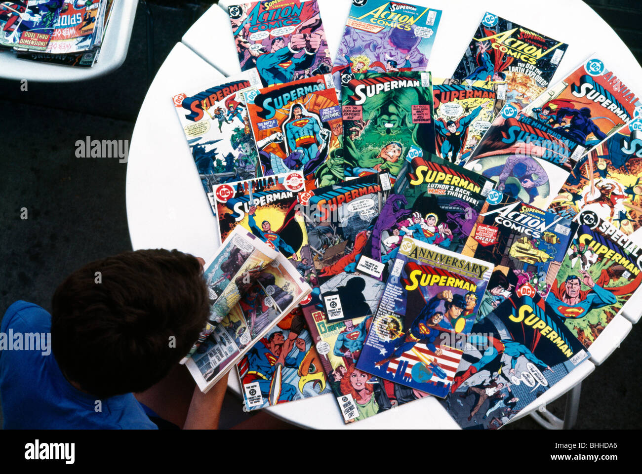 Niño con una colección de cómics de Superman Foto de stock