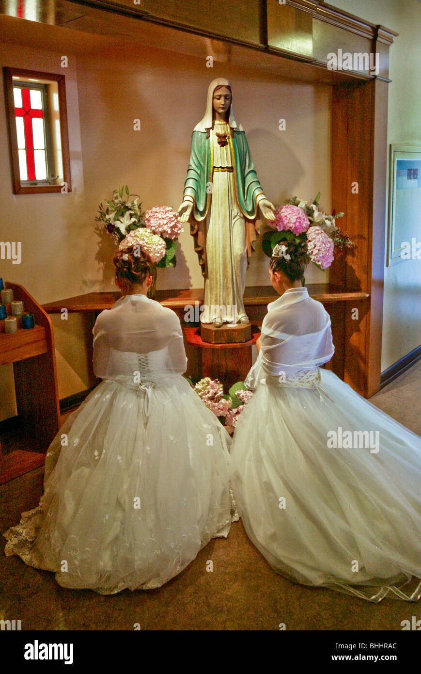 Vestida formalmente las hermanas gemelas adolescentes hispanas arrodillarse ante una estatua sagrada durante su quinceañera Misa en Long Beach, CA iglesia Fotografía de stock - Alamy Vestida formalmente las hermanas gemelas adolescentes hispanas arrodillarse ante una estatua sagrada durante su quinceañera Misa en Long Beach, CA iglesia Fotografía de stock - Alamy