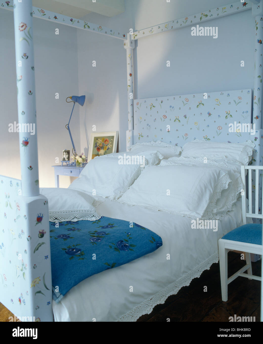 Las almohadas y ropa de cama de color blanco pintado floral cama con dosel  en el dormitorio azul pastel Fotografía de stock - Alamy