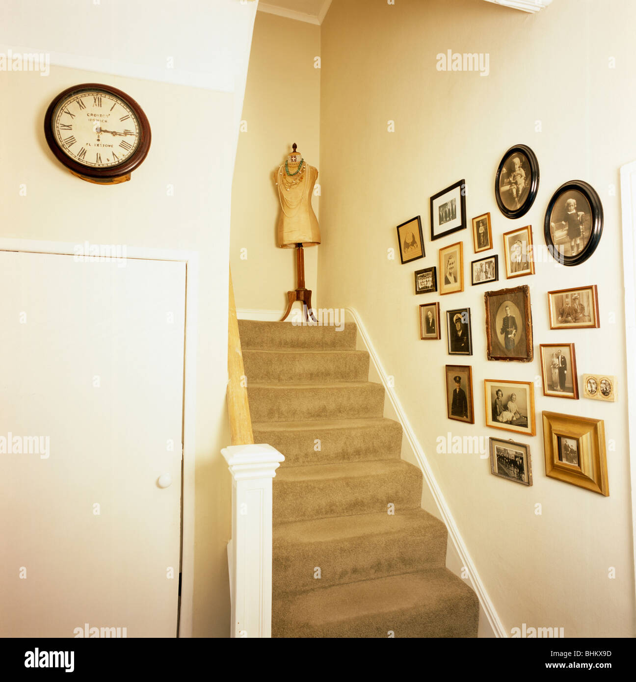 Pareja tomar Deshonestidad Grupo de fotografías familiares en pared sobre la escalera con alfombras de  color beige y el maniquí en la parte superior paso Fotografía de stock -  Alamy