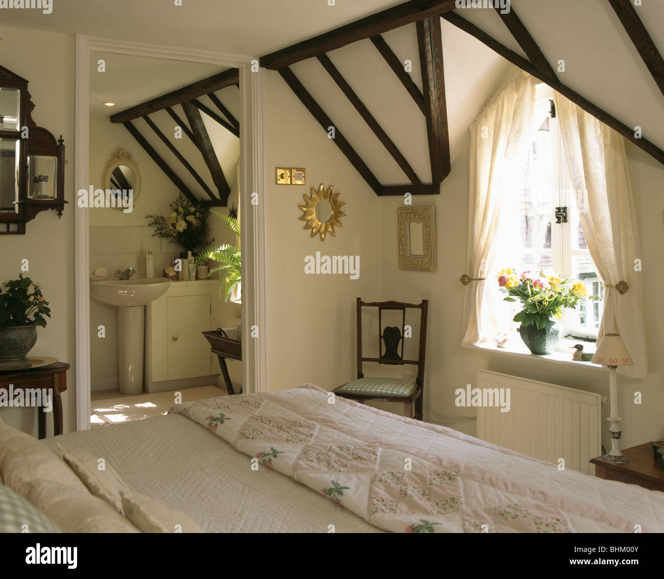 Cortinas blancas encima de una cama individual con ropa de cama blanca y  cojines en dormitorio tradicional con imágenes grandes y telas ciegos  Fotografía de stock - Alamy