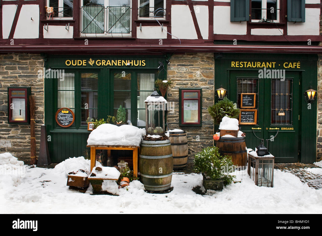 Frente al restaurante en el centro histórico de Monschau en la nieve en invierno, Eifel, Renania del Norte-Westfalia, Alemania Foto de stock