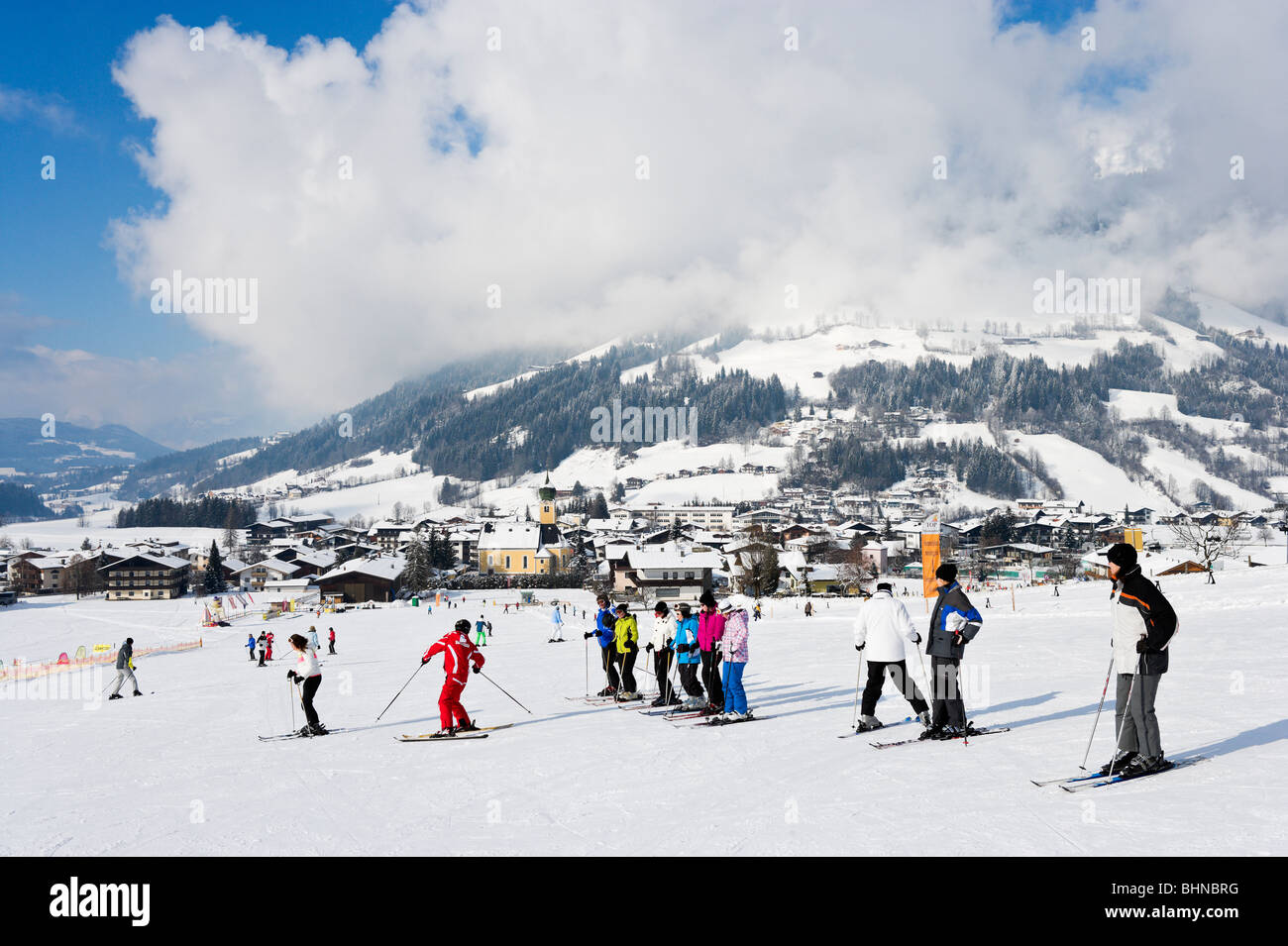 Escuela de esquí lección sobre el vivero laderas justo fuera del centro del resort, Westendorf, Tirol, Austria Foto de stock