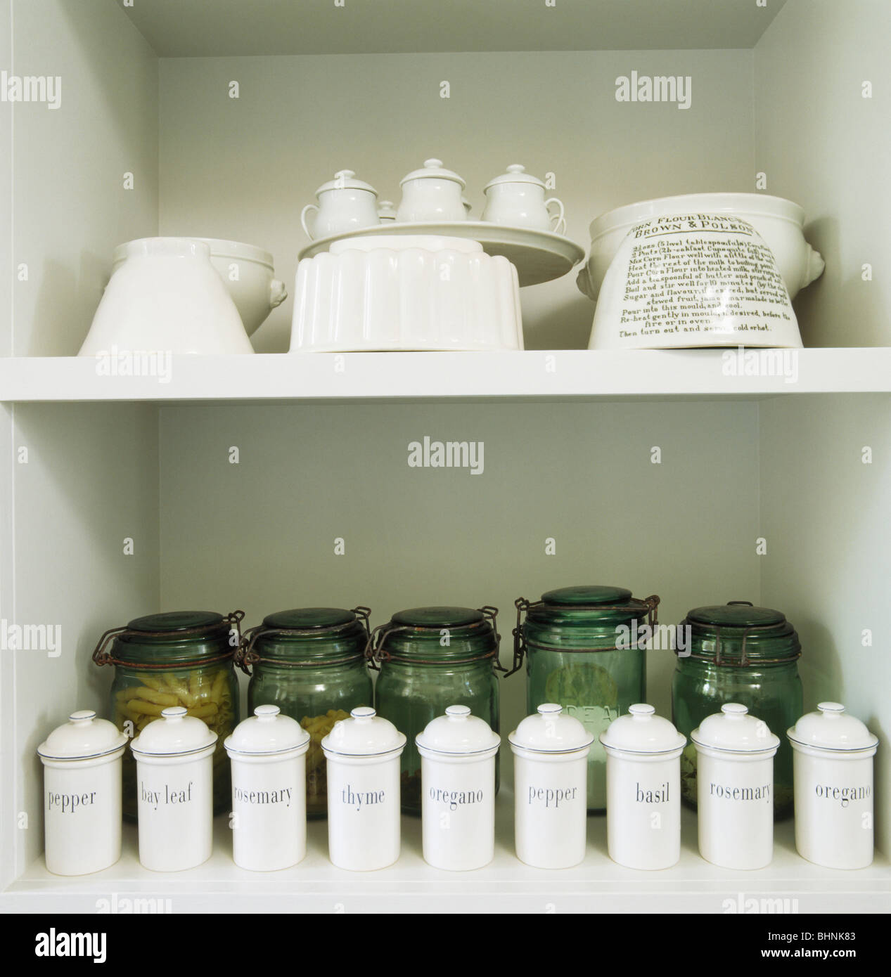 Close-up de almacenaje de cocina tarros de cerámica blanca y jalea moldes  en blanco en los estantes con frascos de vidrio verde Fotografía de stock -  Alamy