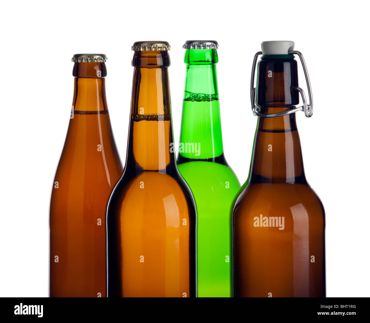 Tops de cuatro tipos diferentes de botellas de cerveza sin etiquetas, cuarteado Foto de stock