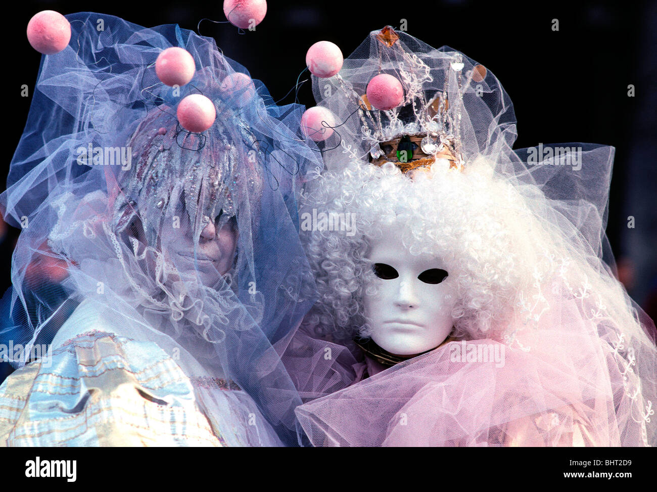 Pareja en pleno carnaval y disfraces trajes de fantasía mostrando pink  bolas al Carnaval de Venecia, Italia Fotografía de stock - Alamy