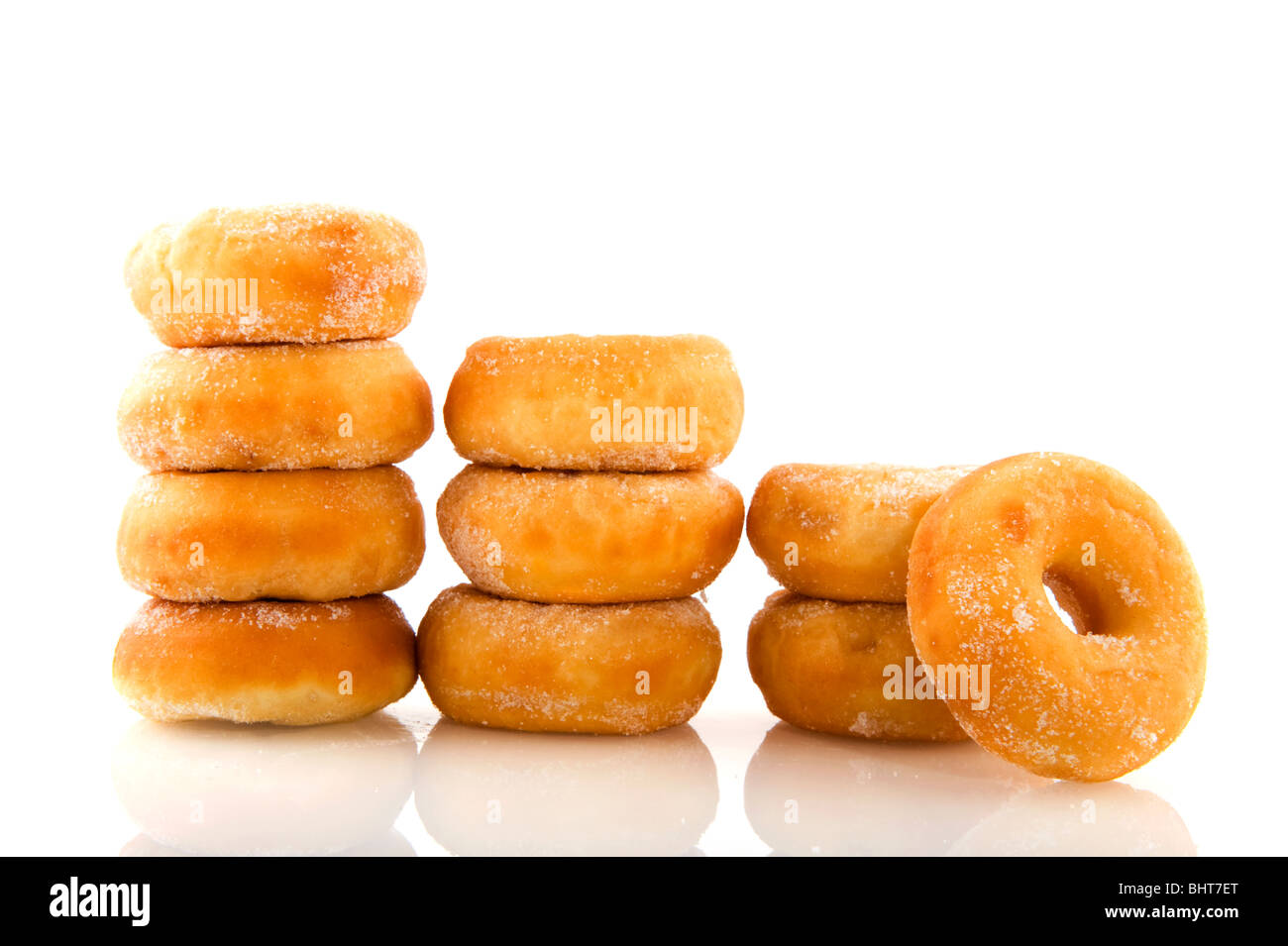 Montones de donuts con azúcar aislado sobre blanco Foto de stock