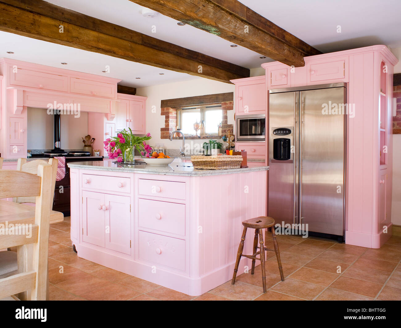 Las unidades montadas de color rosa pastel y unidad de la isla en el país  cocina con gran estilo americano de acero inoxidable nevera-congelador  Fotografía de stock - Alamy