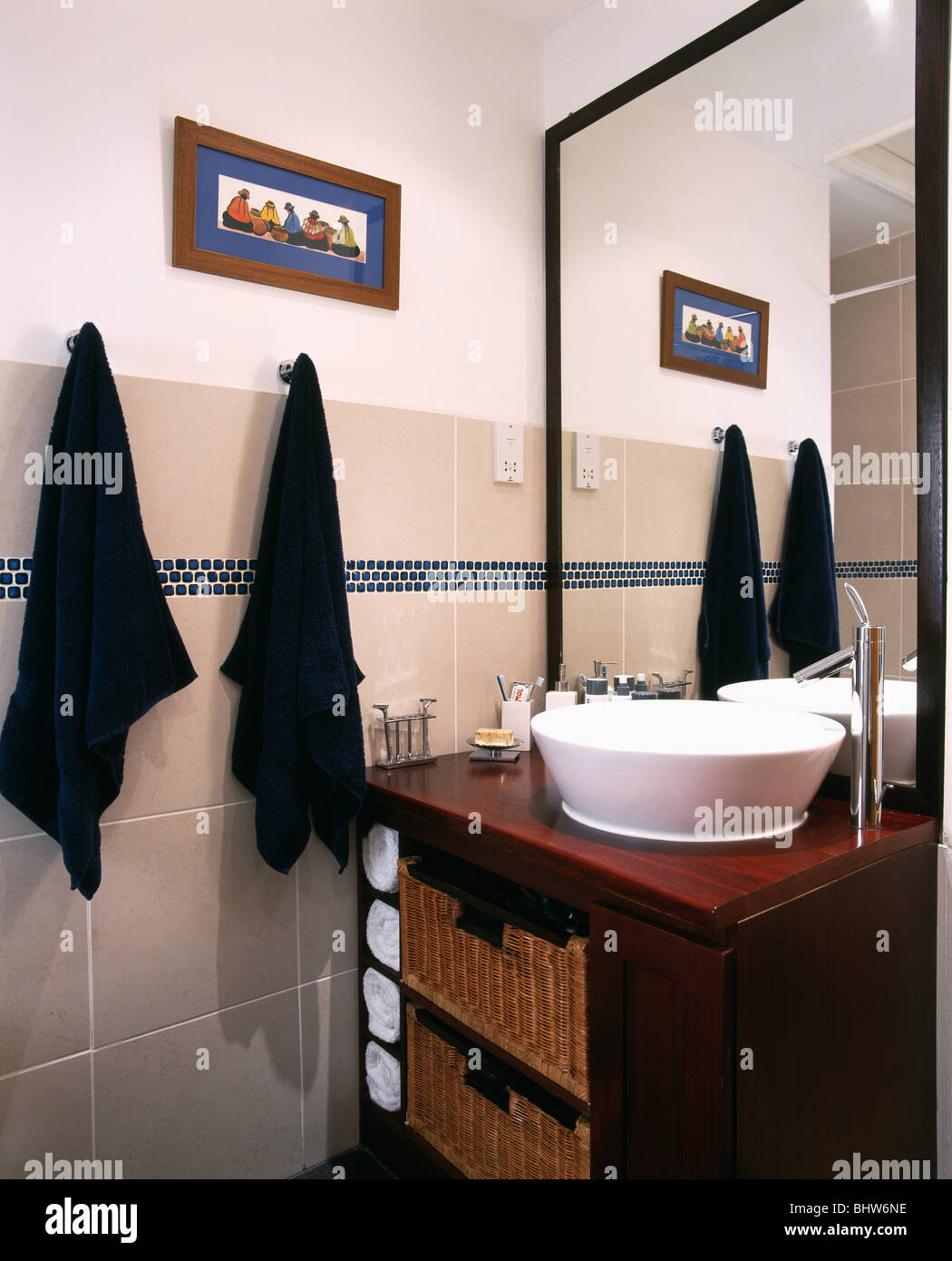 Toallas negras en ganchos al lado de cuenca en blanco debajo de la unidad  de vanidad de madera espejo montado en un cuarto de baño moderno Fotografía  de stock - Alamy