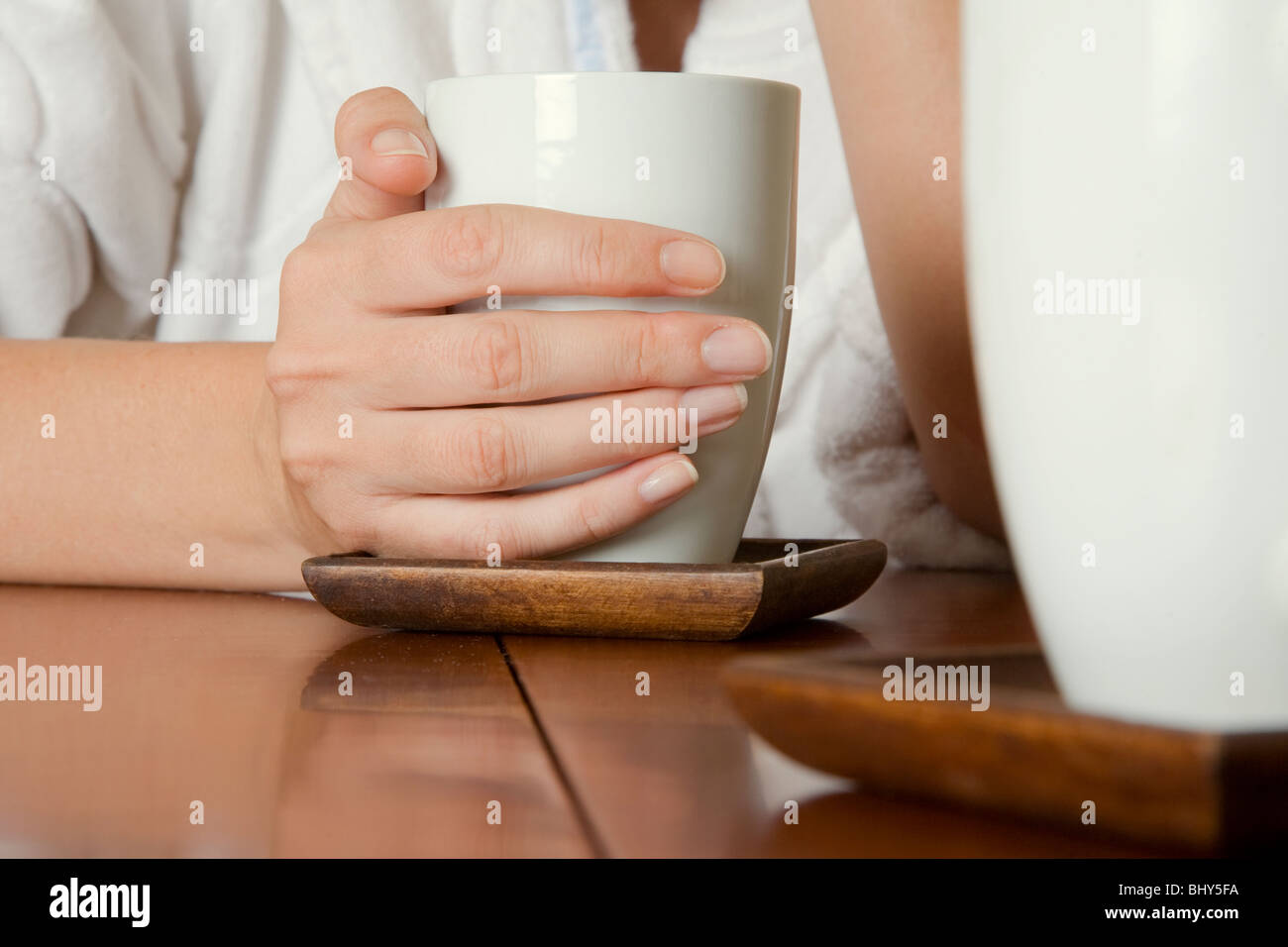 Tiros de ángulo bajo de una mujer en una conversación en un café con su mano alrededor de una taza de café Foto de stock