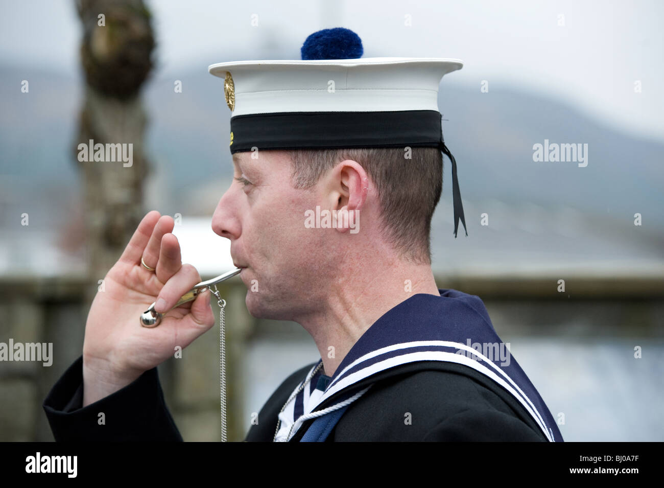 Un marinero líder del Servicio Naval irlandés juega el tubo del Boatswain también conocido como Boatswain's llamada. Foto de stock