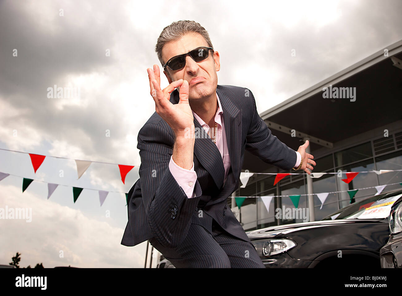 Retrato de vendedor en un concesionario de coches gesticulando Foto de stock
