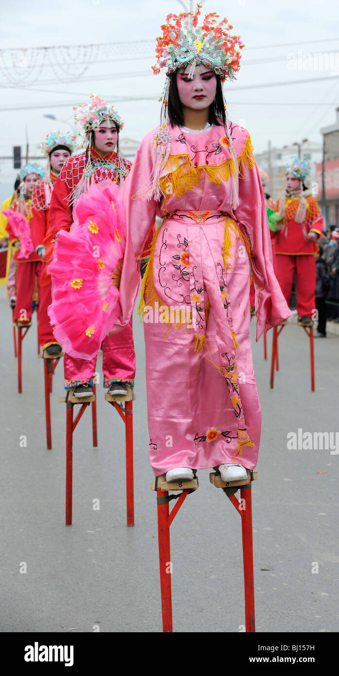 La gente realiza tradicional baile zancos durante Yuanxiao Festival o el Festival de las linternas en Yuxian, Hebei, China. 28-Feb-2010 Foto de stock