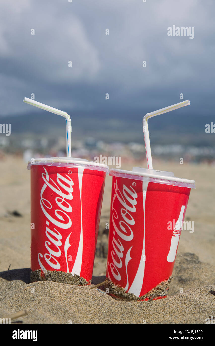 Dos desechables vasos de Coca Cola en la playa Foto de stock
