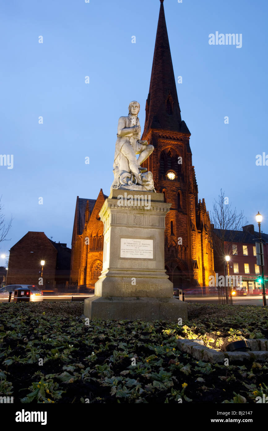 El poeta Robert Burns estatua en el centro de la ciudad de Dumfries con Iglesia Greyfriars detrás en la noche Scotland Reino Unido Foto de stock