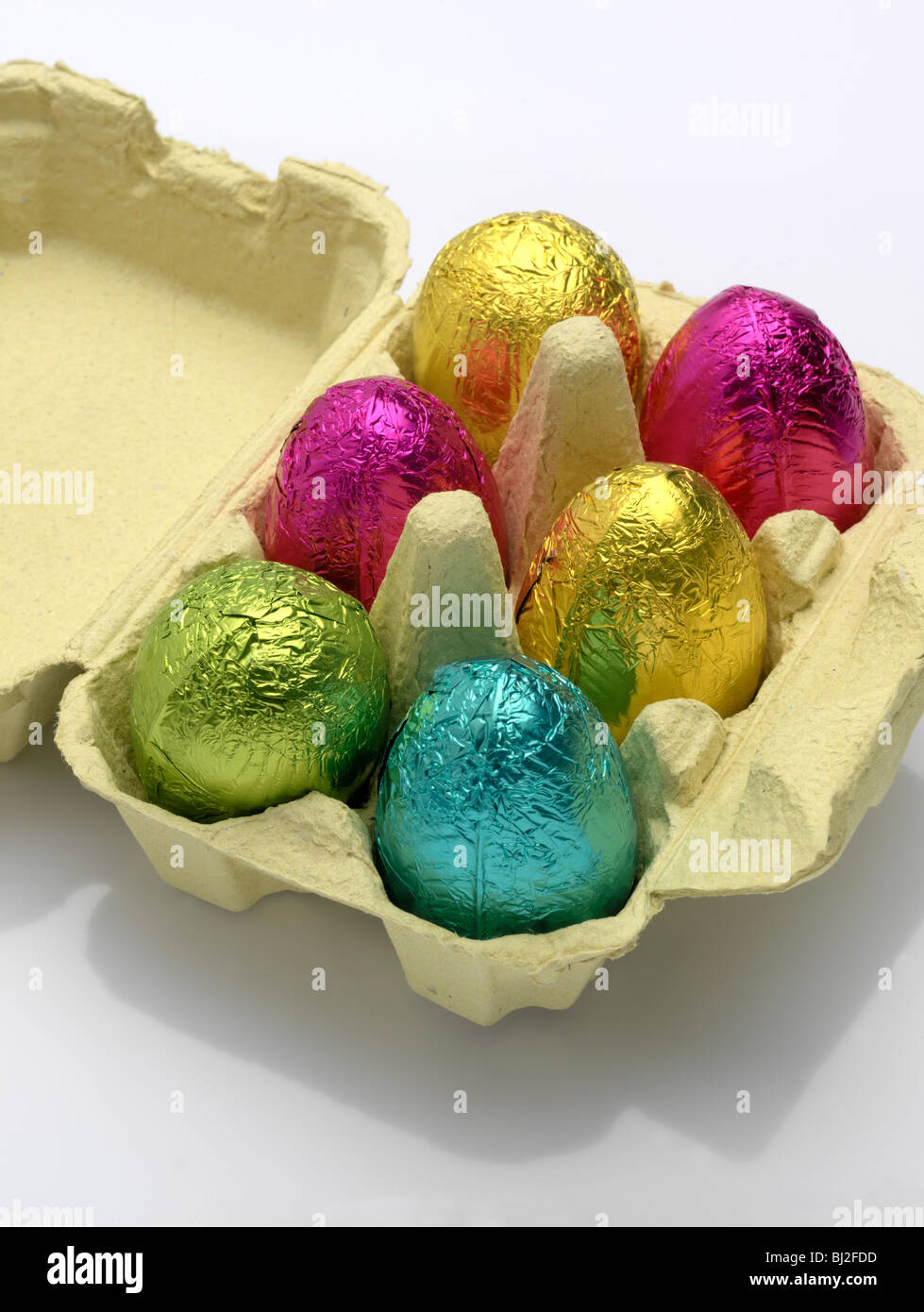 Huevos de Pascua de chocolate de colores brillantes en una caja de huevo. Foto de stock