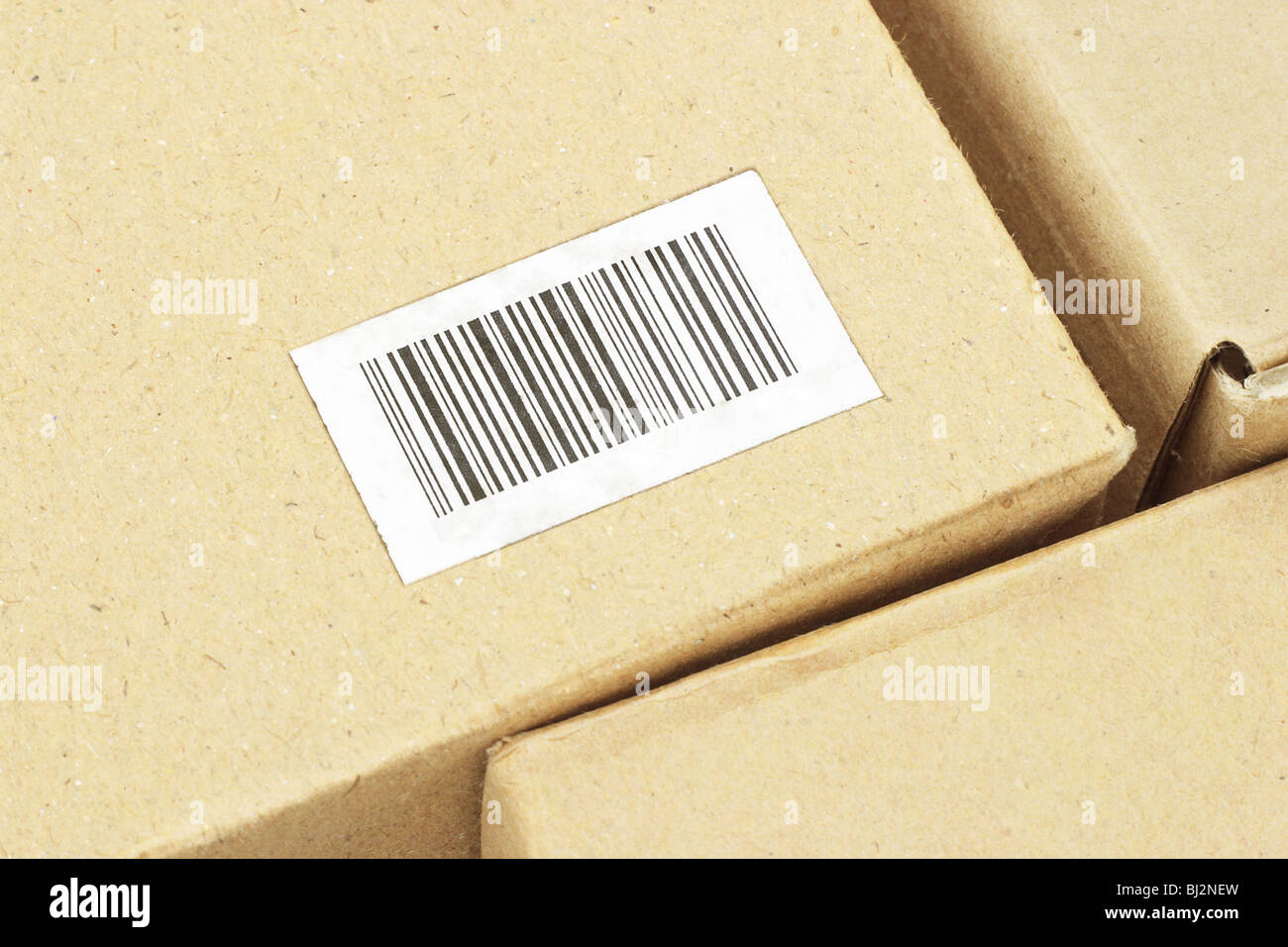 Cerca de la etiqueta de código de barras en la caja de cartón (código de barras creada aleatoriamente) Foto de stock