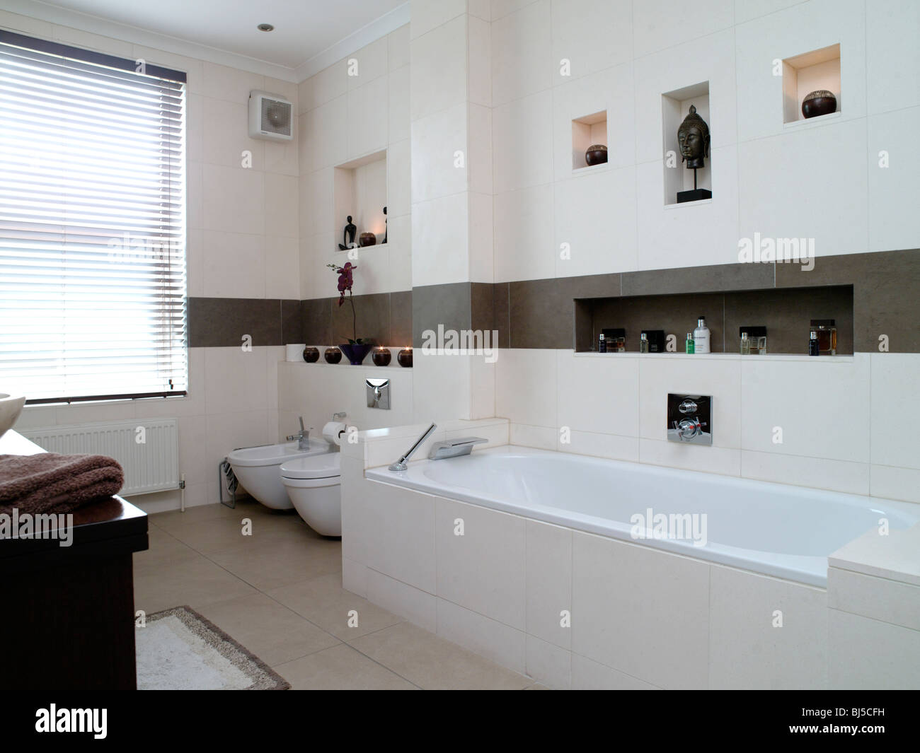 Modernos baños alicatados en blanco y azulejos de color marrón,su y