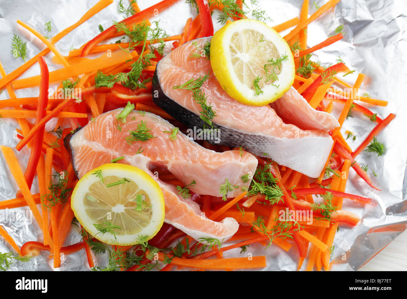 Filetes de salmón crudo con limón y verduras en una lámina Fotografía