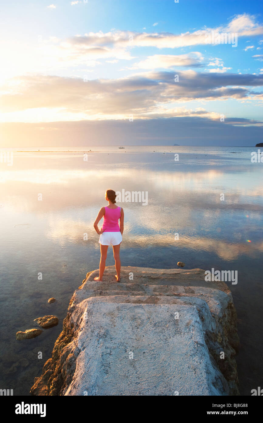 Chica de pie al final del muelle mirando hacia sunset Matabungkay; Batangas; sur de Luzón, Filipinas Foto de stock