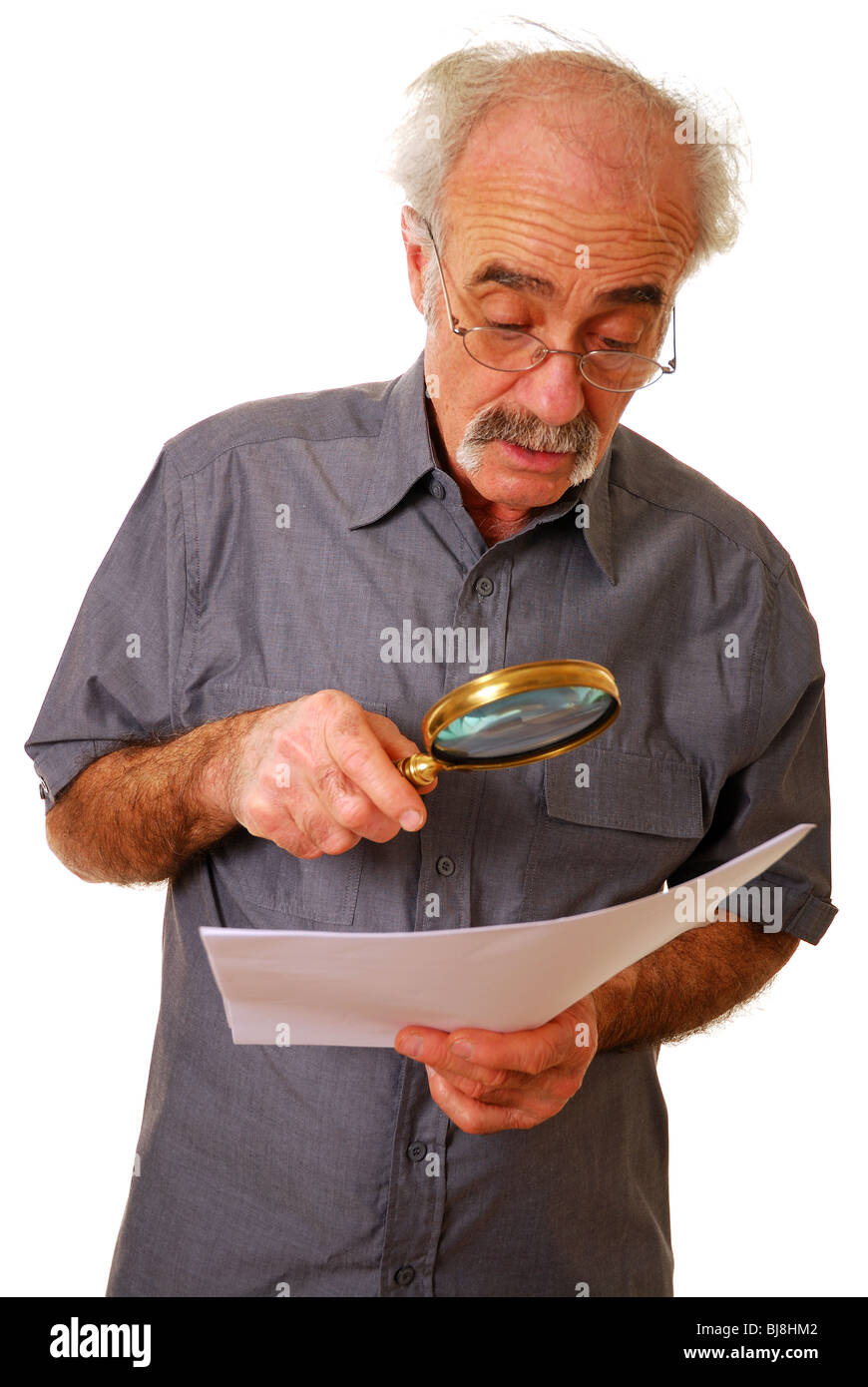 Anciano con lupa para leer Foto de stock