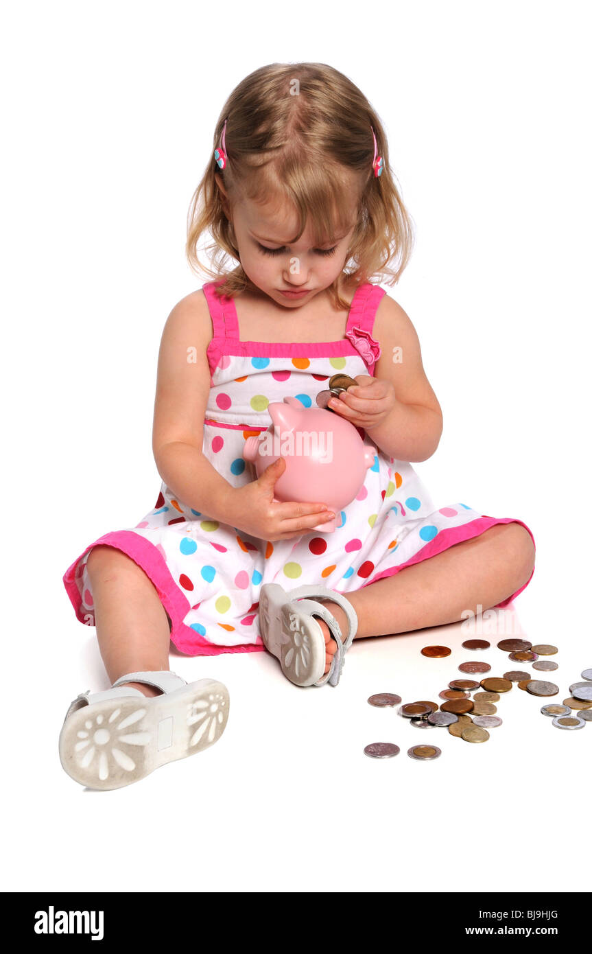 Joven insertar monedas en la hucha Foto de stock