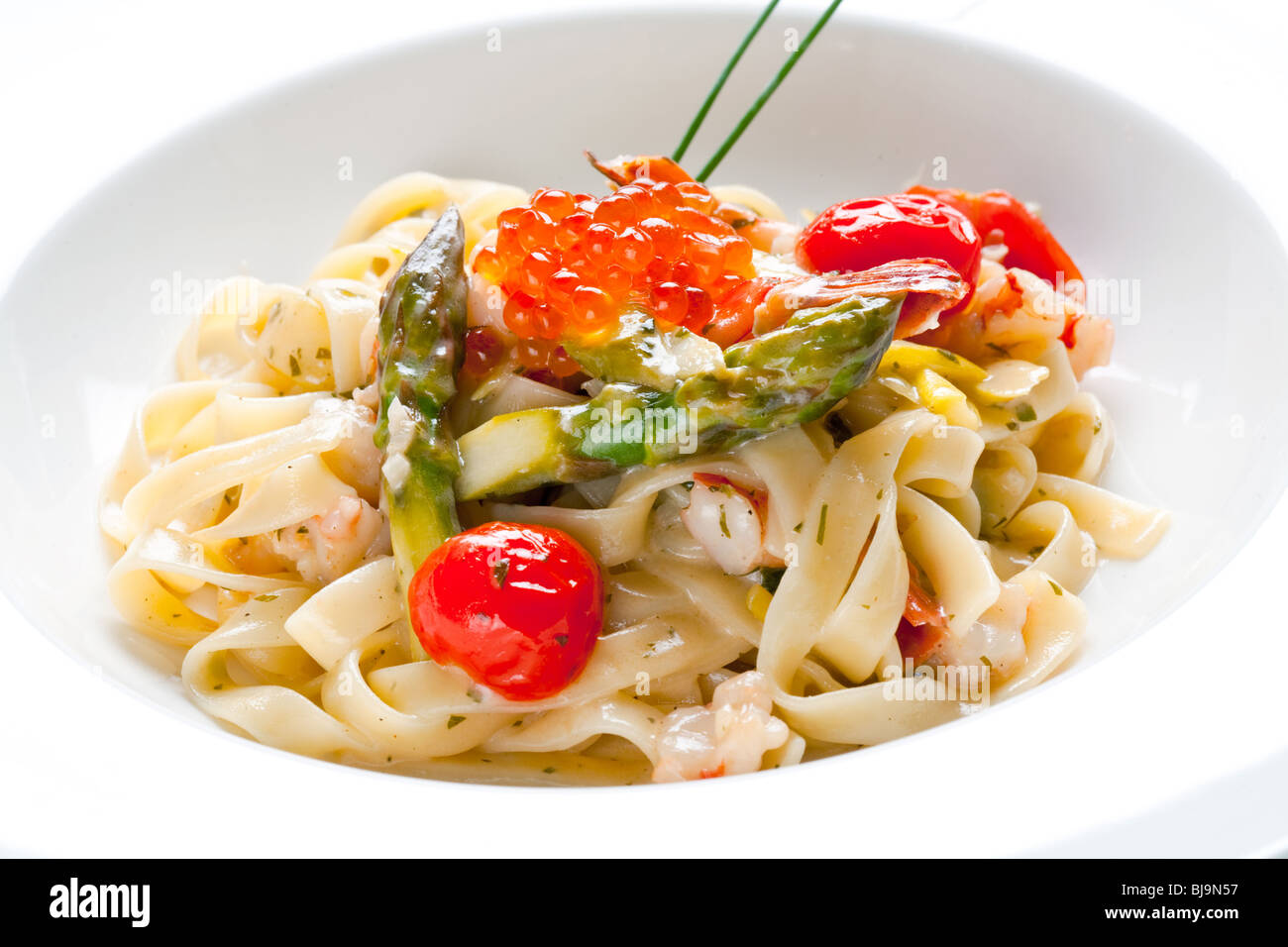 Fideos italianos con caviar rojo y espárragos Foto de stock