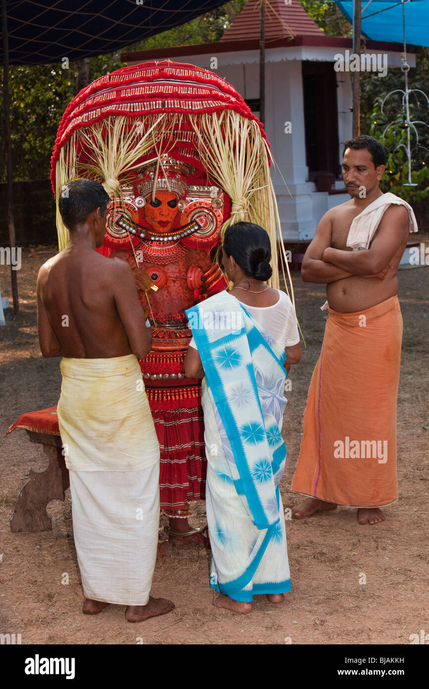 India, Kerala, Kannur (Cannanore), Theyyam, deidad serpiente Naga Kanni dando bendición a devoto femenino Foto de stock