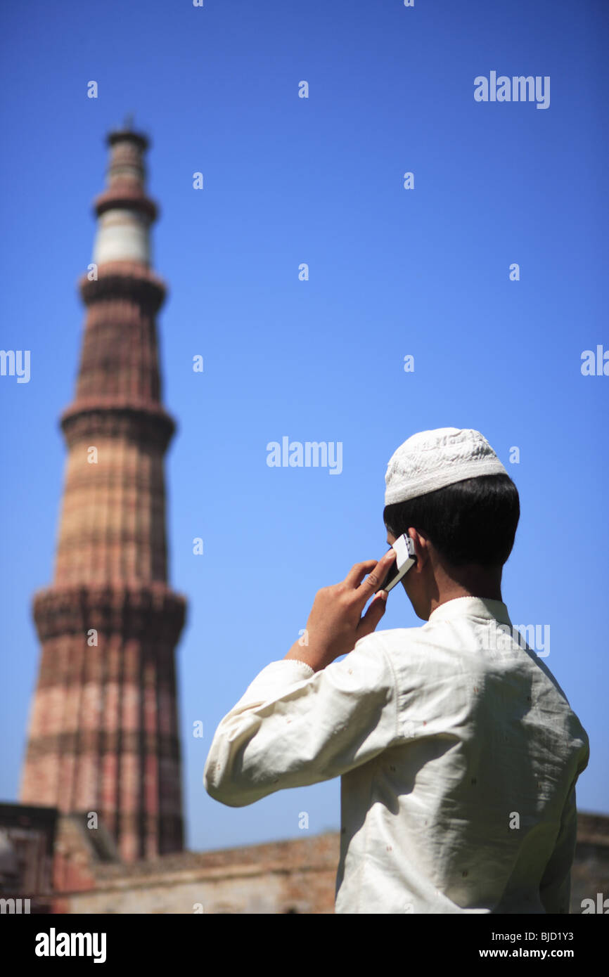 Chico musulmán hablando por teléfono móvil en el arte Indo-Muslim Qutab Minar ; ; ; ; sultanato de Delhi Delhi India Foto de stock