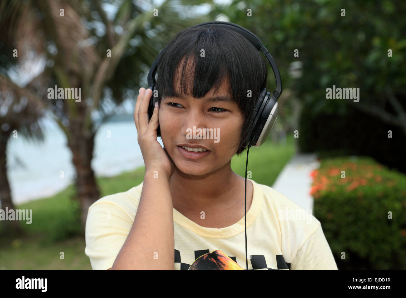 Una niña tailandesa escuchando música Foto de stock