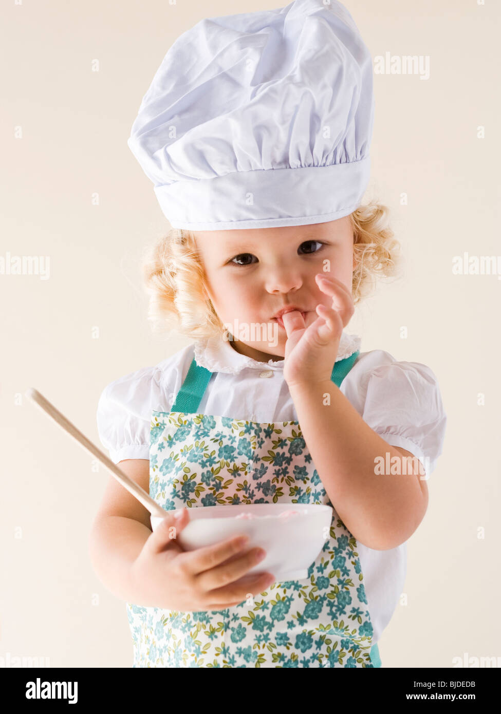 Niña llevando un gorro de cocinero y sosteniendo un cuenco Fotografía de  stock - Alamy