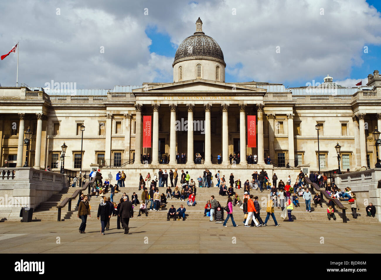 Una escena con mucho movimiento en los escalones de la Galería Nacional en Trafalgar Square, Londres Foto de stock