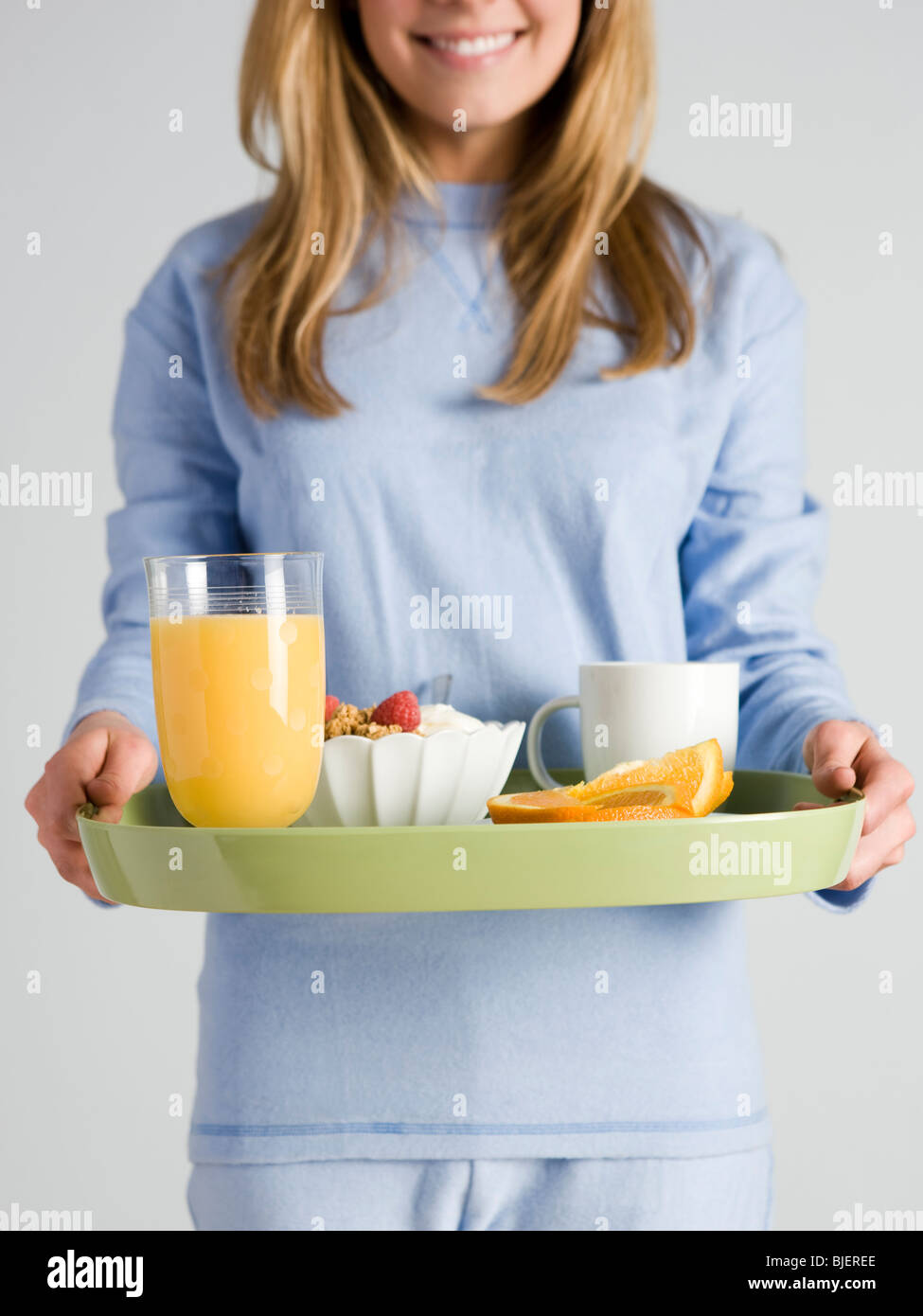 Mujer que llevaba el desayuno en una bandeja Foto de stock