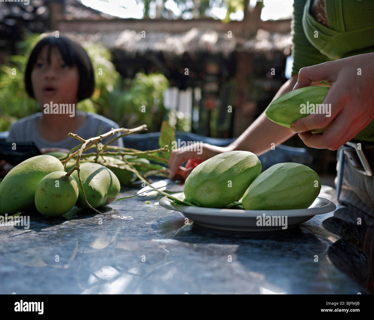 Madre e hija preparando una comida de la fruta del mango verde