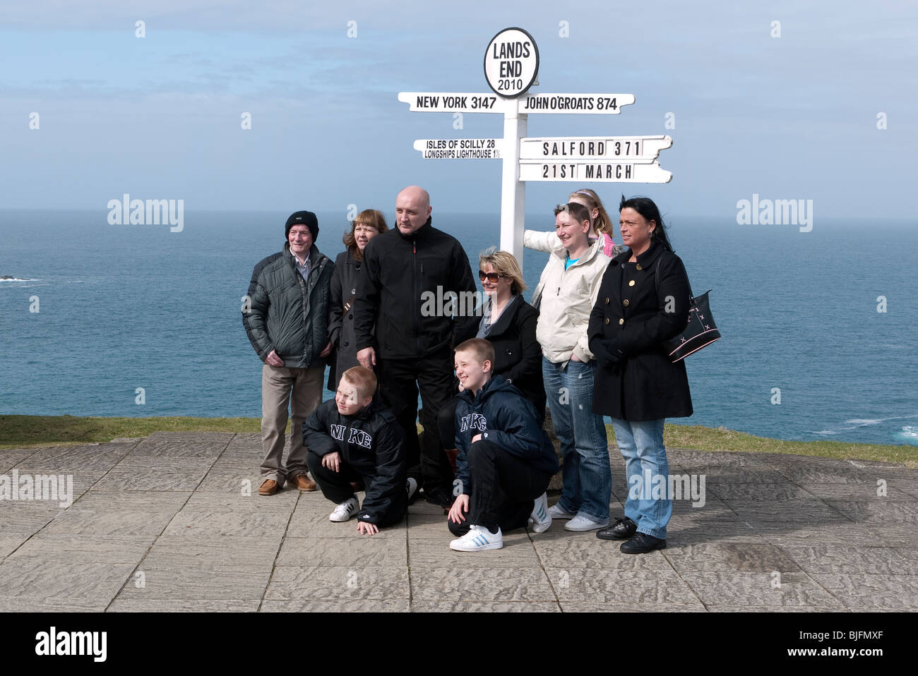 Familia en Land's End signpost Cornwall UK Foto de stock