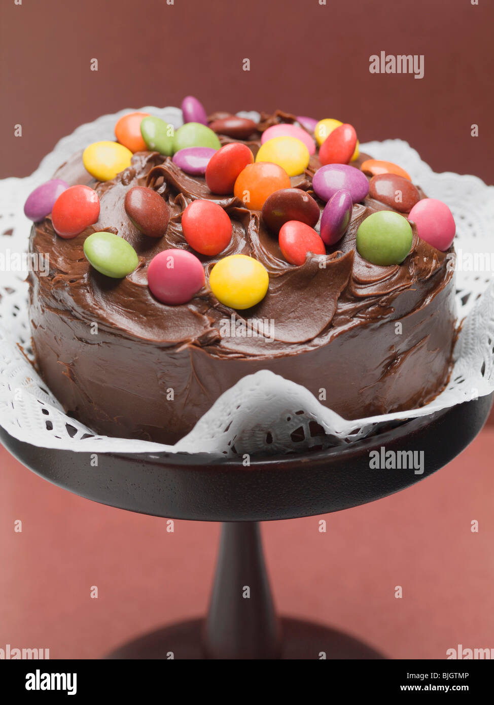 Tarta de chocolate con chocolate de colores pastel de frijoles en stand  Fotografía de stock - Alamy