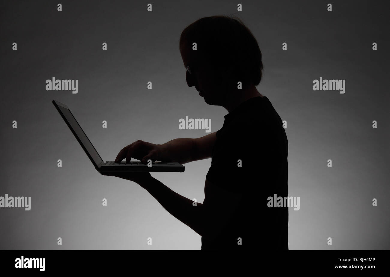 Hombre con un portátil. Símbolo: el robo de datos, delitos informáticos, etc. Foto de stock