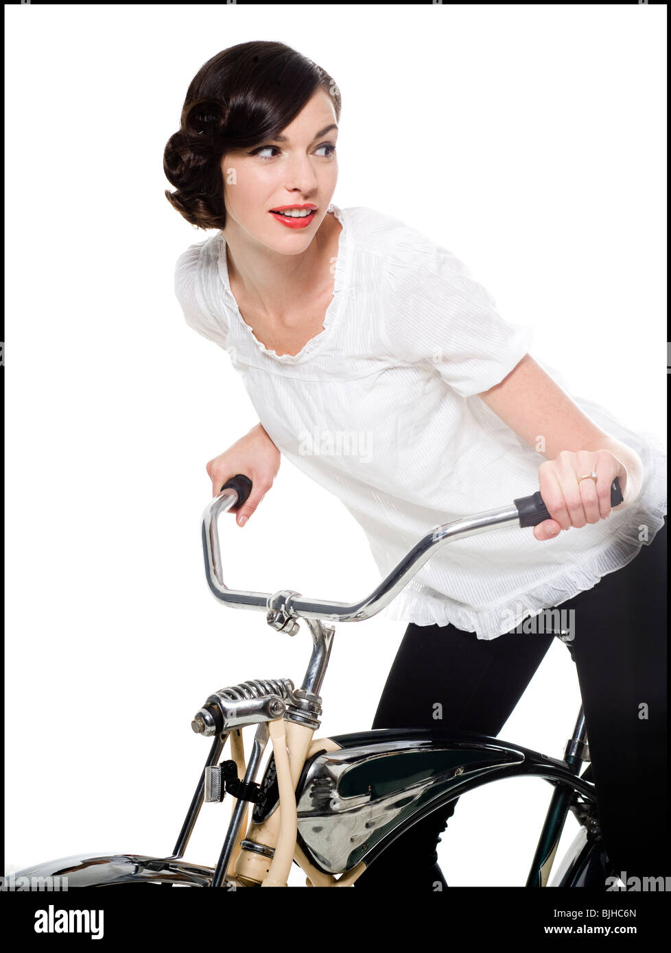 Mujer con el cabello en un peinado de Hollywood clásico con reminiscencias  de la década de 1940 andar en bicicleta Fotografía de stock - Alamy