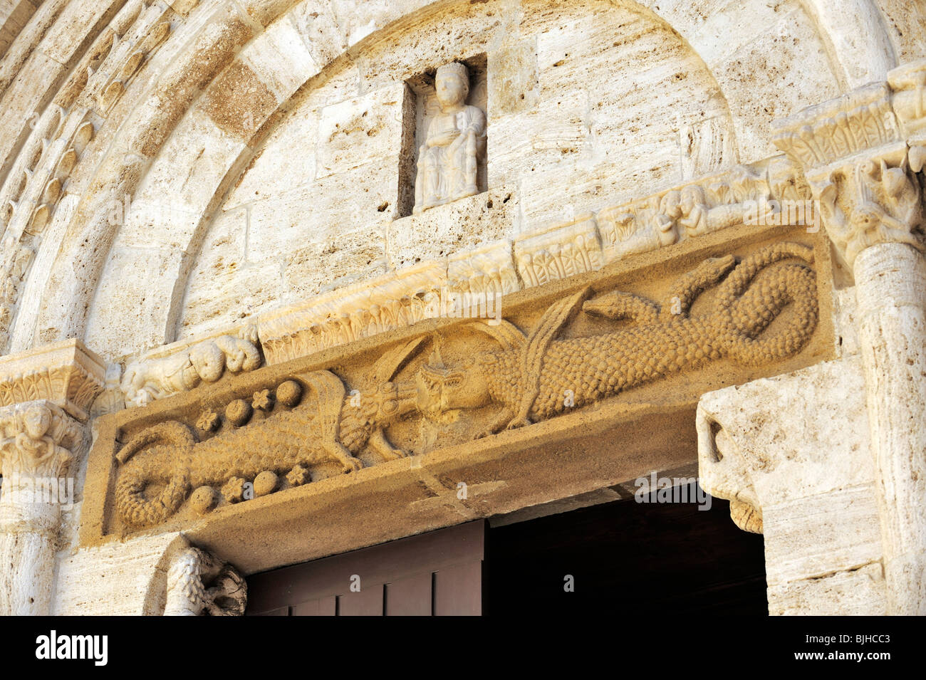 Collegiata iglesia de San Quirico d'Orcia, Toscana, Italia. 12C esculturas románicas de criaturas fantásticas arriba portal principal Foto de stock