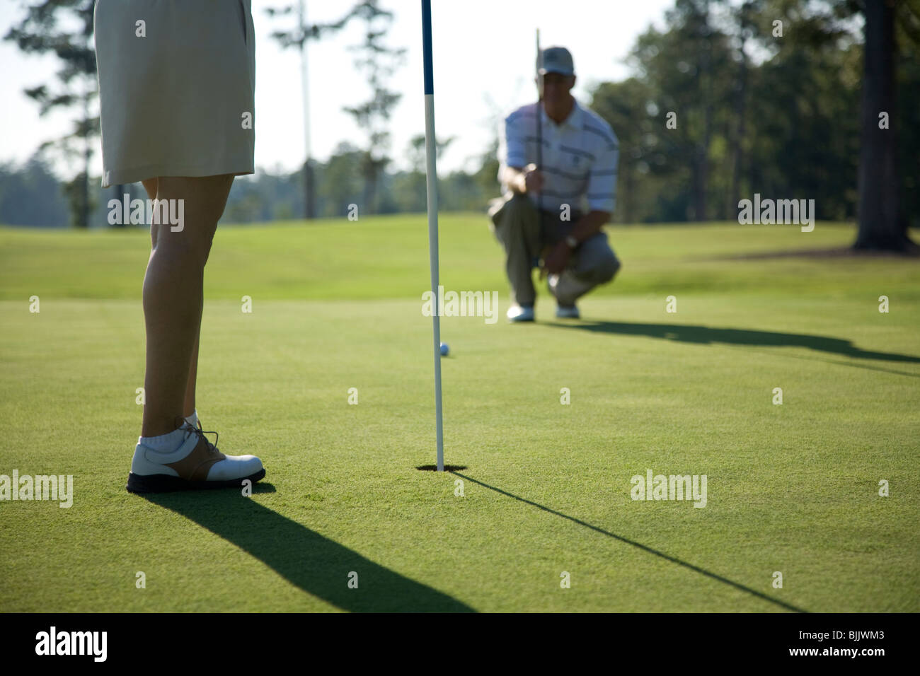 Golfista preparándose para golpear una pelota de golf Foto de stock