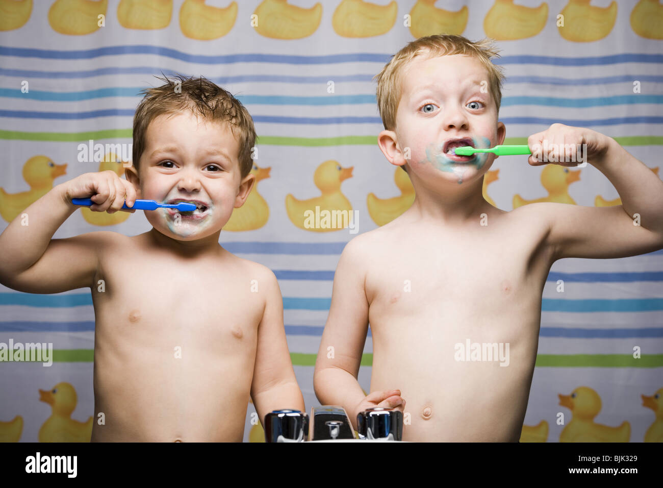 Dos niños cepillarse los dientes en el lavabo del baño Foto de stock